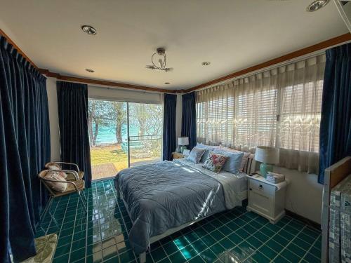 a bedroom with a bed and a large window at The Rich Instantly Home in Sathani Huai Yang