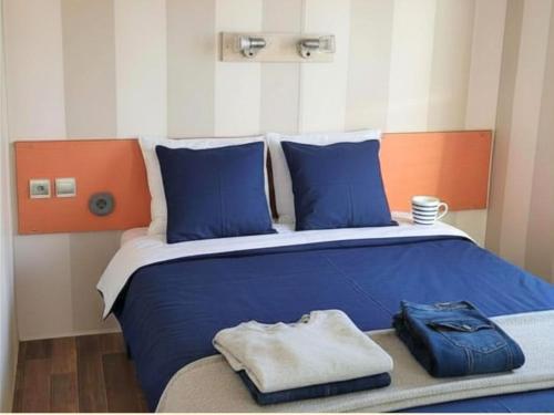 a large bed with blue sheets and blue pillows at Aloha Camping Club in Reynès