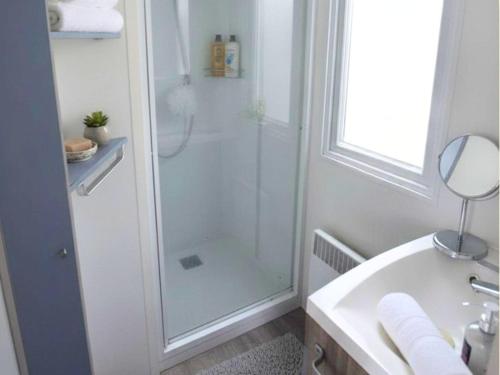 a white bathroom with a shower and a sink at Aloha Camping Club in Reynès