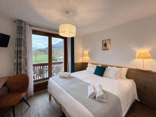 a bedroom with a large bed and a balcony at L'Echo des Montagnes Armoy in Armoy