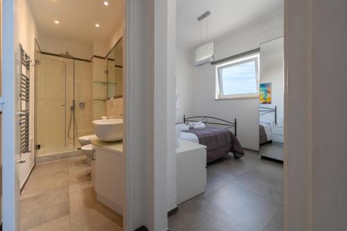 a bedroom with a bed and a bathroom with a sink at Casa Leucosia in Capri