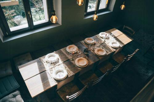 a wooden table with plates and glasses on it at 18Th-Century Stone House By River In Romagna in Sarsina