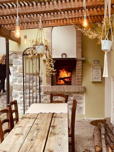 a dining room with a table and a fireplace at 18Th-Century Stone House By River In Romagna in Sarsina