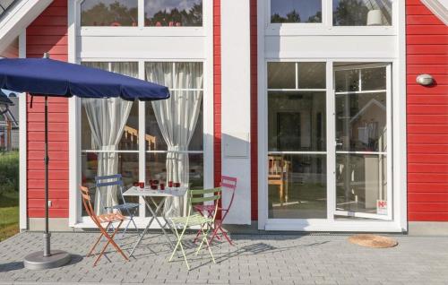 a table and chairs and an umbrella in front of a building at Haus Hallon in Wandlitz