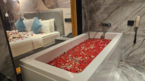 a bathroom with a tub filled with red peppers at Le Sparrow Beach- Rooms in Mangalore