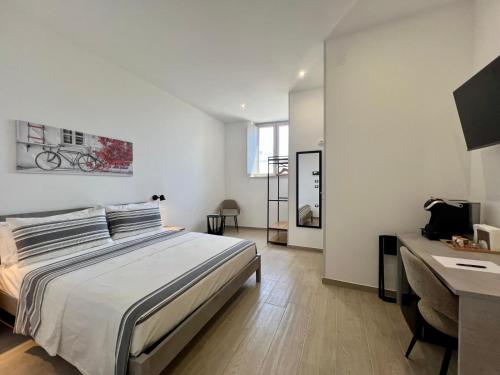 a white bedroom with a bed and a desk at HOMIA guest house by MOH in Grottaglie