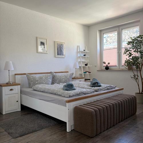 a bedroom with a large white bed with a window at Feriennest am Meer Warnemünde in Warnemünde