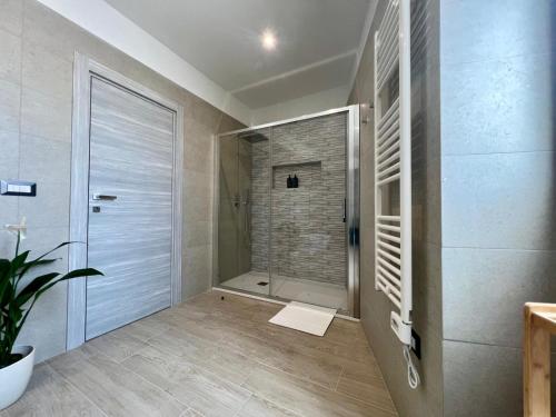 a bathroom with a shower and a glass door at HOMIA guest house by MOH in Grottaglie