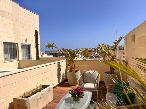 a balcony with a table and a chair on a building at Palazzo De La Sengle Boutique Hotel in Senglea