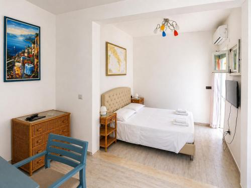 a bedroom with a white bed and a blue chair at Maré Rooms Castro in Castro di Lecce