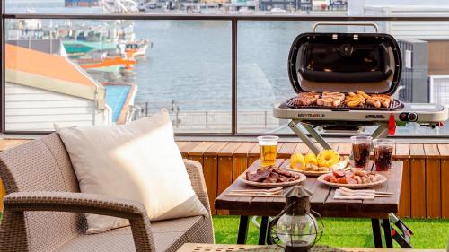 a grill on a table with food and drinks on a balcony at Tongyeong Present Gamsung Pension in Tongyeong
