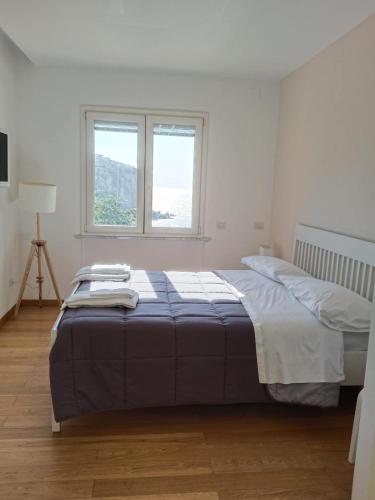 a bedroom with a bed and two windows at White Stylish Apartments 2 in Vico Equense