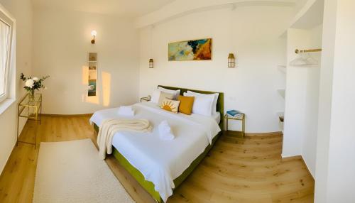 a bedroom with a large bed with white sheets at Casa de Oaspeti 2 Mai in 2 Mai
