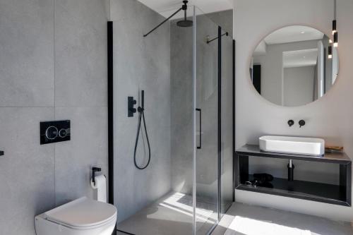 a bathroom with a shower and a toilet and a mirror at Villa Acquariva Private Heated Pool in Salò