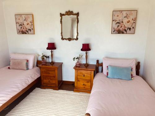 two beds in a room with a mirror and two night stands at Seaview in Duneen