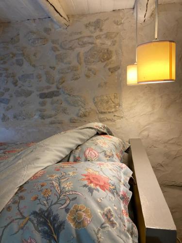 a bedroom with a bed and a table and a wall at Petit cocon à 10min d'Avignon in Pujaut