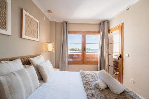 a bedroom with a bed with a view of the ocean at CARABELA 94 in Alcudia