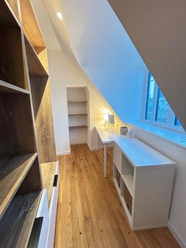 an attic room with a desk and a window at Le Breizh Break Lounge in Roscoff