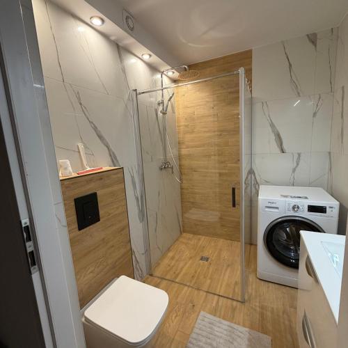 a bathroom with a washing machine and a washer at MAAN Apartments in Augustów