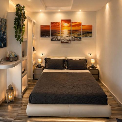 a bedroom with a bed in a room with paintings on the wall at Barracuda Suite Sea View & Dinner Experience in Ischia Town