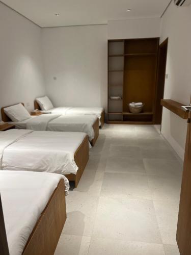a row of beds in a room with a bathroom at Mykonos Resort in Abu Dhabi