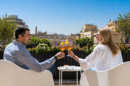a man and woman holding up glasses of wine at Hotel Moderno in Bari