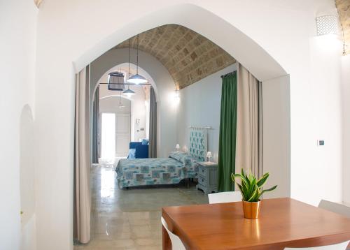 a living room with a table and a bedroom at Felline centro storico in Felline