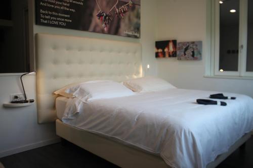 a bedroom with a large white bed with shoes on it at Amata Valgre Affittacamere, comfort e pulizia eccezionali!! in Olginate