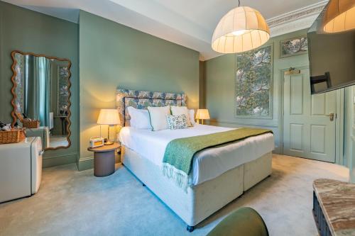 a bedroom with a large bed and a tv at Crescent Inn by Maison Pierre in Ilkley