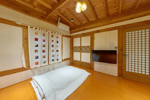 a room with a bed and a tv in it at Hanok Moonstay in Gyeongju
