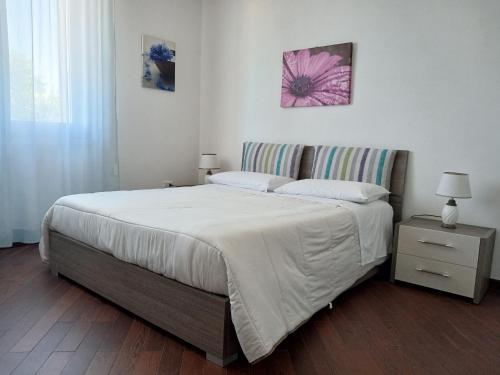 a bedroom with a large bed and a nightstand with a bed sidx sidx sidx at Villa del Mar Country Loft in Sassari