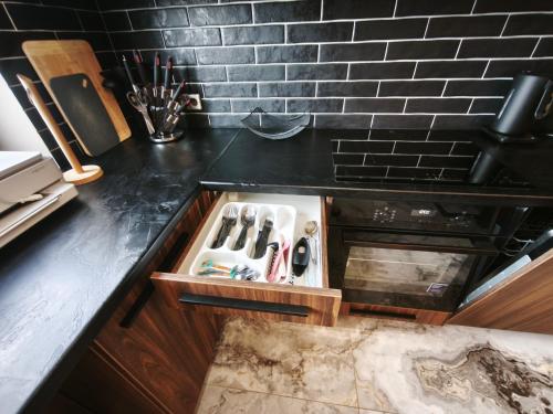 a kitchen with a black counter top with a knife drawer at Panorama View Suite in Jelgava