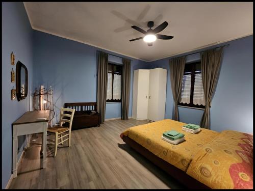a bedroom with a bed with a ceiling fan and a desk at Narnia e la Rocca di Albornoz in Narni