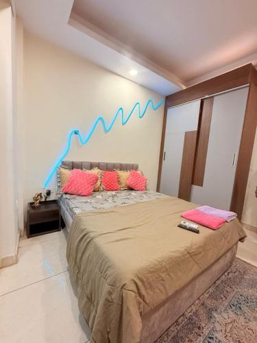 a bedroom with a large bed with pink and blue pillows at Vetri Homes IV in Zirakpur