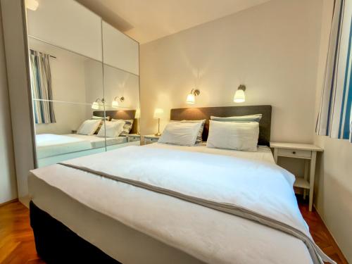 a large white bed in a room with a mirror at Jellyfish in Malinska