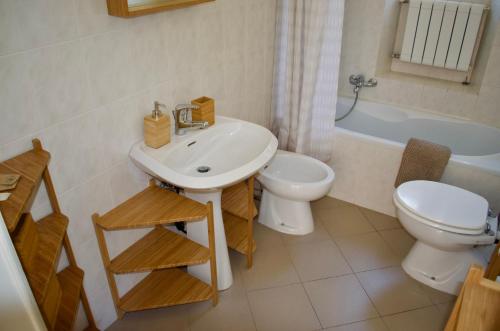 a bathroom with a sink and a toilet and a tub at Casa Corten, Vista Lago in Cerro Lago Maggiore
