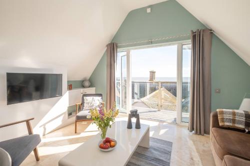 a living room with a table and a large window at York House in Aldeburgh