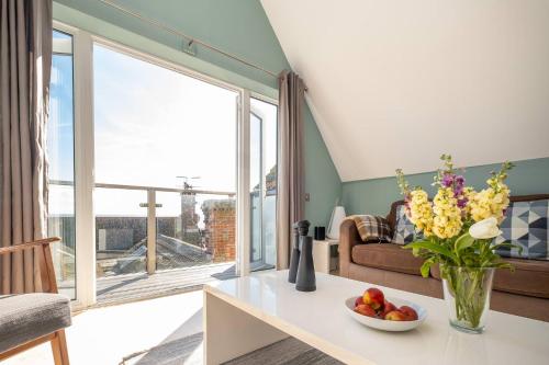 a living room with a table with a vase of flowers at York House in Aldeburgh