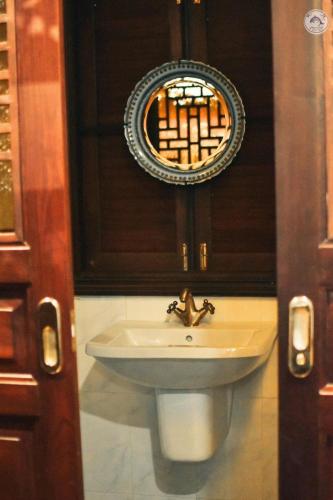 a sink in a bathroom with a mirror and a mirror at สงขลาแต่แรก แอนทีค โฮเท็ล Songkhla Tae Raek Antique Hotel in Songkhla
