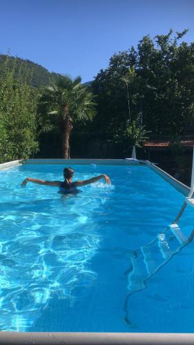 a man swimming in a large blue swimming pool at Conca Verde Appartaments in Bellagio