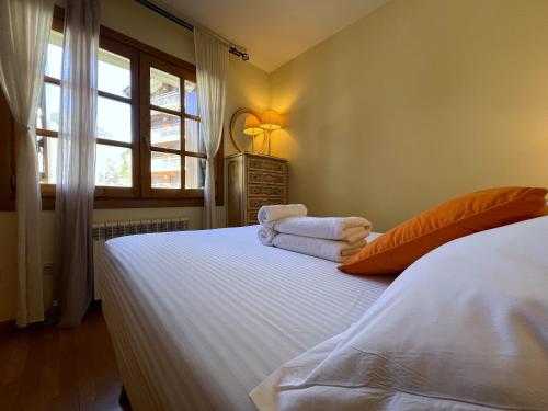 a bedroom with a bed with towels on it at AC Apartaments Canillo in Canillo