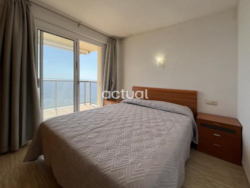 a bedroom with a bed and a large window at President A-9 in Platja d'Aro