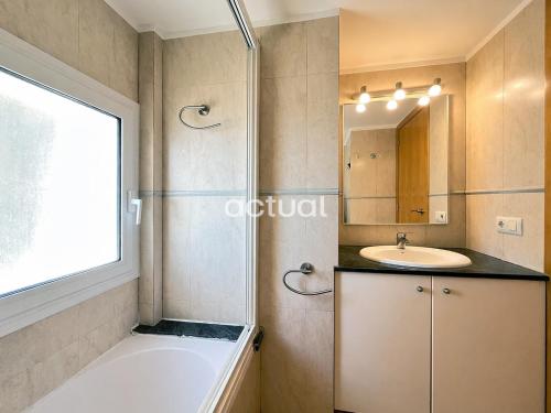 a bathroom with a tub and a sink and a mirror at President A-9 in Platja d'Aro