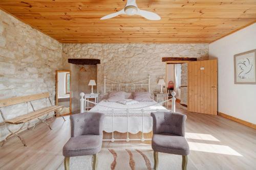 a bedroom with a white bed and two chairs at Chambres D'hôtes La Boriette in Castelnau-de-Montmiral