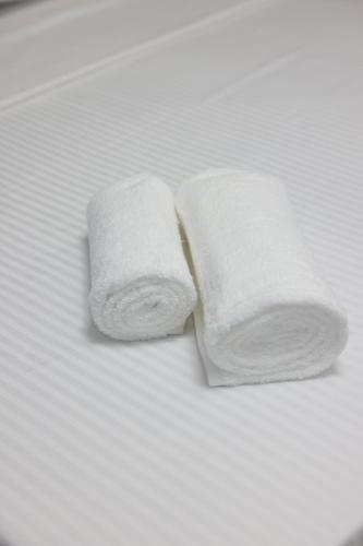 two rolls of white towels on a bed at Ergi Riverside Villas in Zues