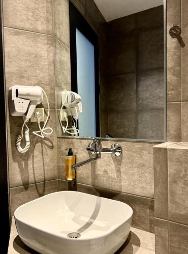 a bathroom with a white sink and a mirror at Chiko Group in Aspindza