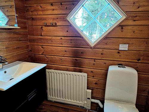 a bathroom with a toilet and a sink and a window at Aurora Camp Kiruna in Kiruna