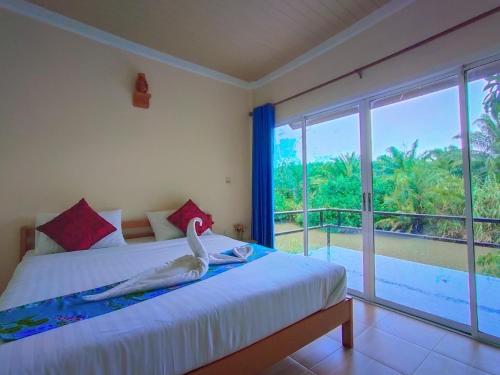 a woman laying on a bed in a room with a window at Ingtarn Ressort At thasala อิงธารรีสอร์ท ท่าศาลา in Ban Nai Thung