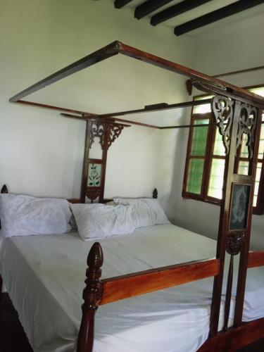 a bedroom with a canopy bed with white sheets at The Twende Villa on Beach in Paje