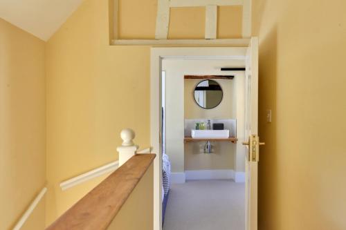 a hallway with yellow walls and a wooden table at Finest Retreats - Josua, Maldon in Maldon